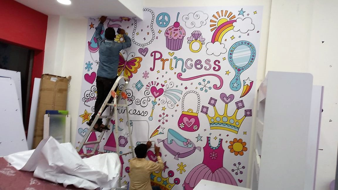 Two men pasting a full-sized wall sticker for children’s bedroom