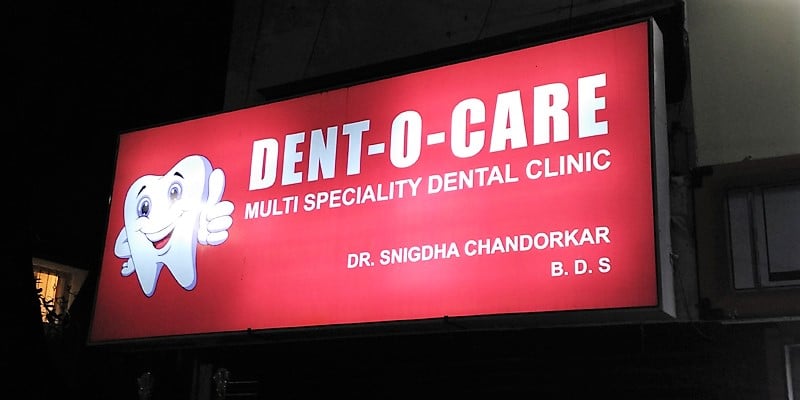 flex printed backlit glow sign board with lights glowing within for the dent-o-care clinic