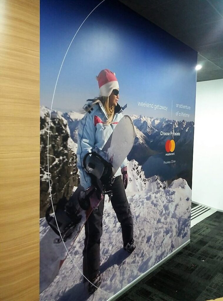 Large-sized custom wallpaper print of a woman holding a ski board installed in an office