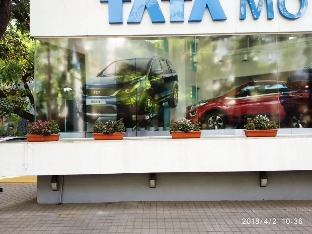 transparent glass print on the frontage of the Tata car showroom showing an image of a grey car