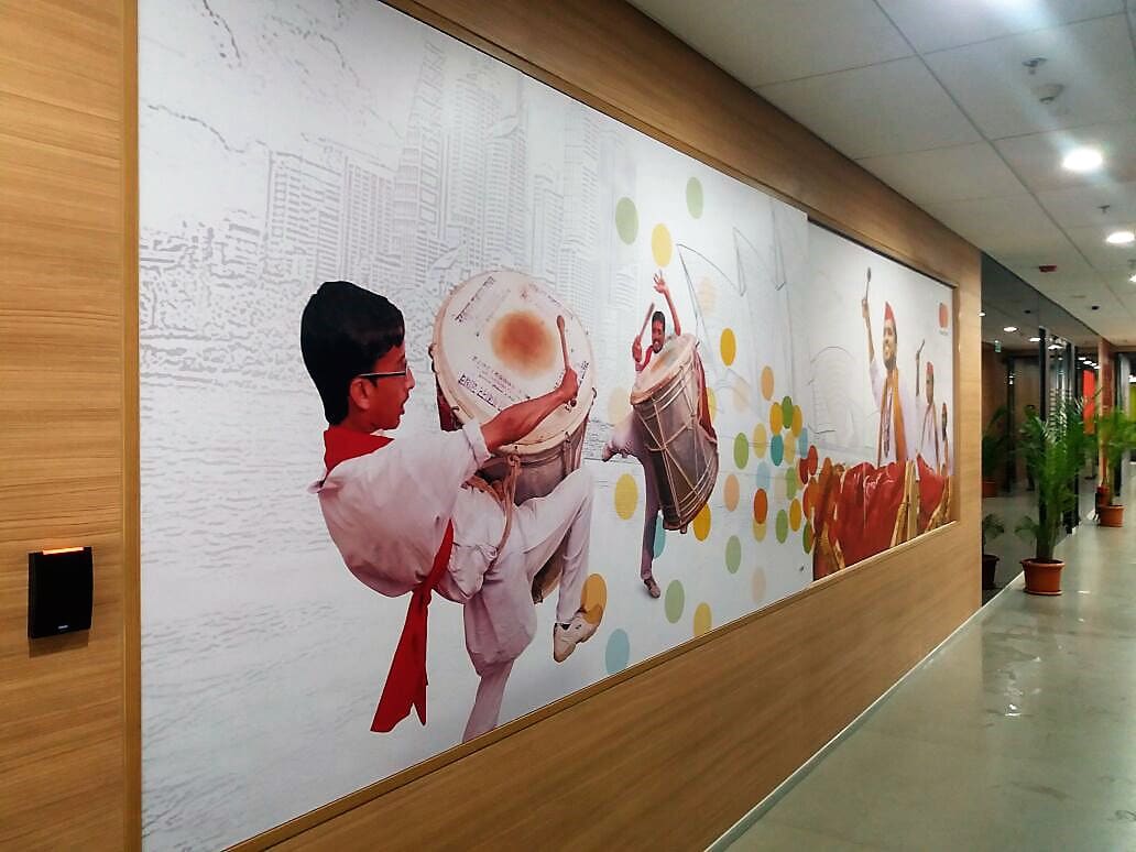 An image of a team of people playing the traditional dholak during a festival celebration converted into a full-sized wall sticker and pasted in an office