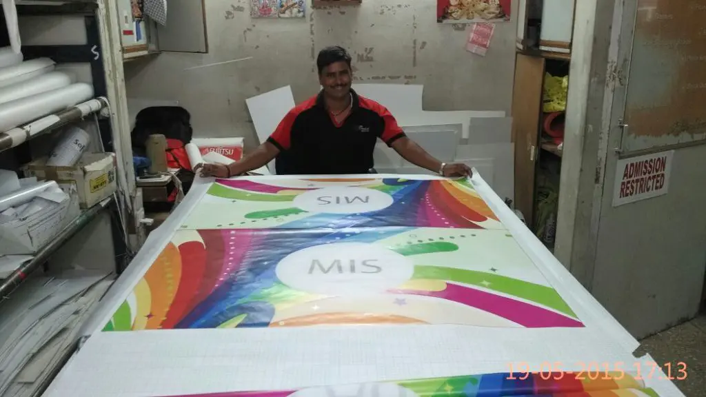 person laying out a large piece of cloth on which the custom design of a company's flag has been printed