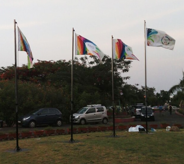 four custom printed flags hoisted on flagpoles billowing in the wind