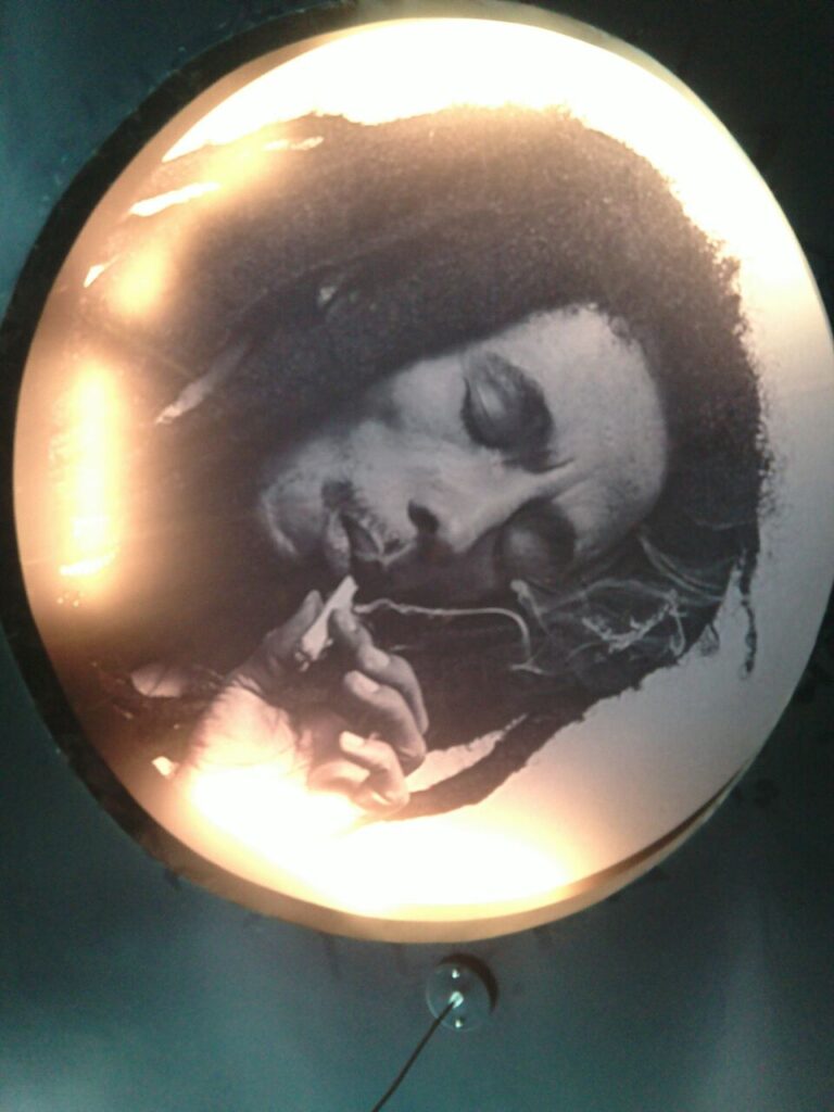 Unique interior decoration idea wherein a side lit image of Bob Marley is pasted as wallpaper on the ceiling of a hotel