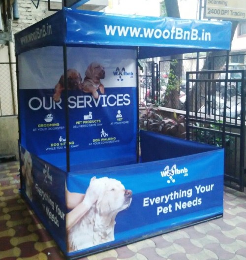 Side view of portable canopy tent branded with services provided by Woof BnB pet care company