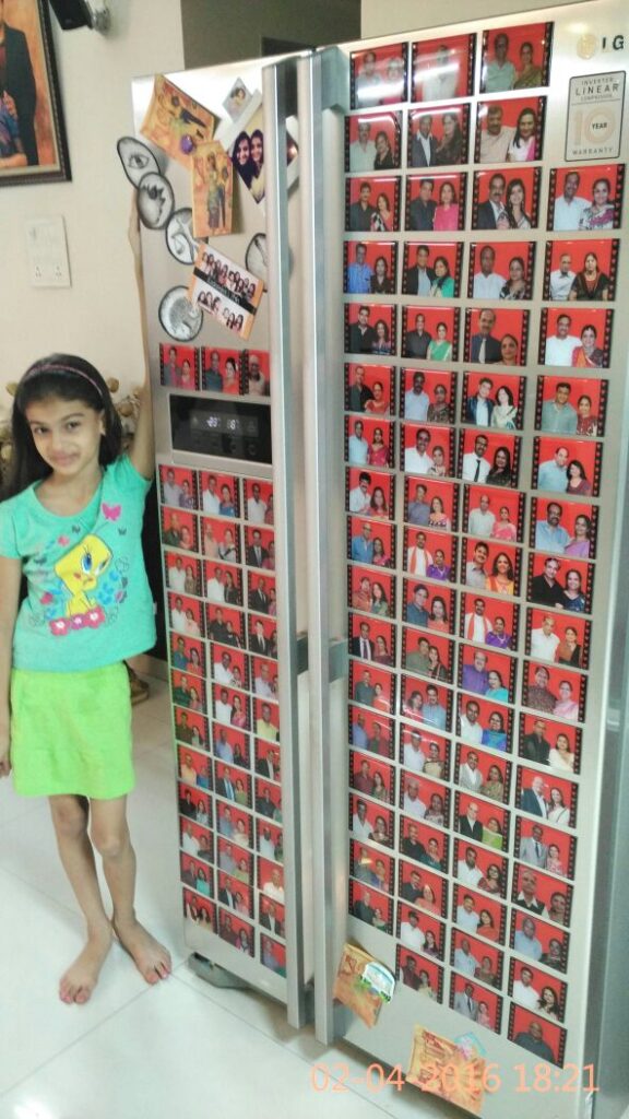 personalized photos printed on magnetic stickers and placed on a fridge door with a girl posing on the side