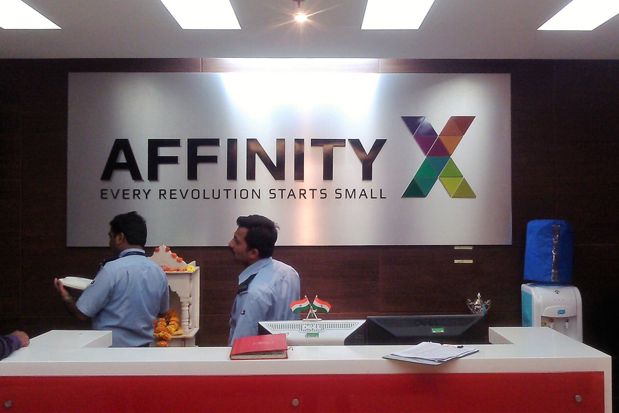 Laser cut acrylic name board displaying the name and logo of the Affinity X company installed on an ACP panel and displayed in the reception area of their office