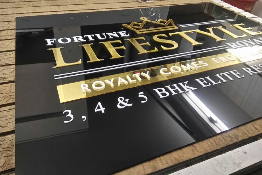 This image shows a acrylic sign board with a black base plate with company logo on top