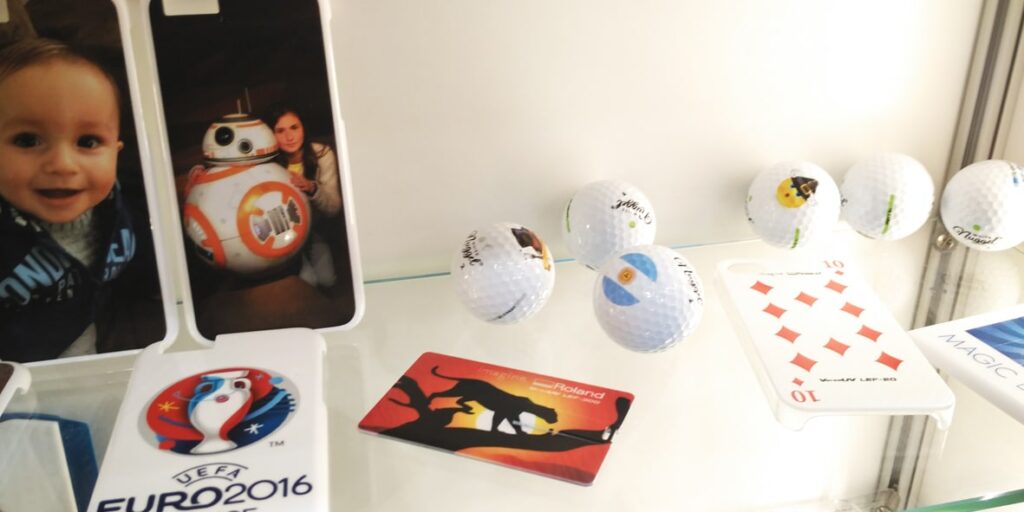 uv flatbed printing examples showing direct prints on golf balls mobile covers and a USB pen drive