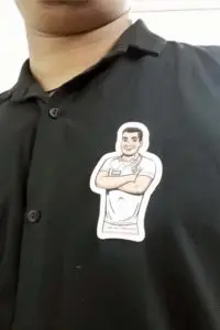 a badge made of acrylic pinned on a black t-shirt