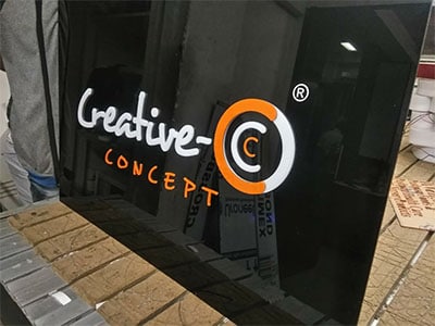 This image shows a lit acrylic shop board created for the web design and graphic institute, Creative Concepts.