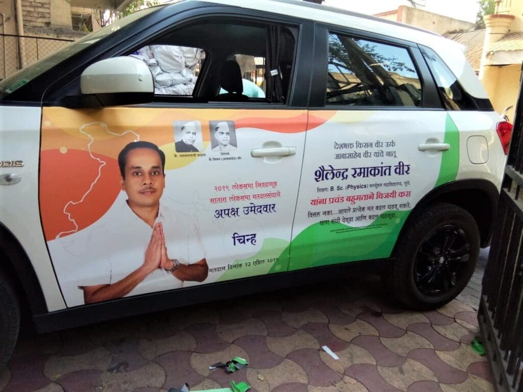 Colourful advertisement for a political candidate pasted on the side of a car using printed vehicle vinyl