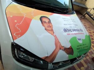 Vehicle advertising of a political candidate on the hood of car using printed removable adhesive vinyl