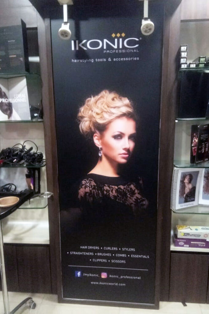 advertisement for beauty products of the Ikonic company printed on a vinyl banner and pasted in a salon