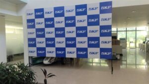 Event backdrop of step and repeat artwork of a company logo printed on flex stretched on a metal frame with T-stands