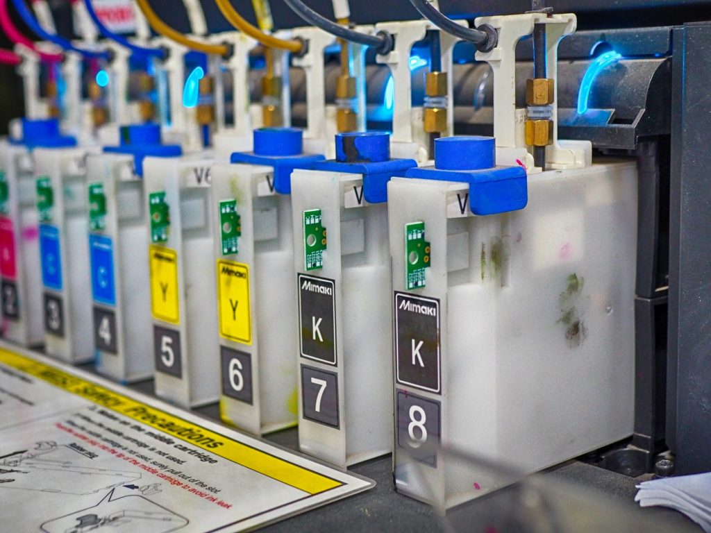 CMYK color ink cartridges installed in a wide format inkjet printer