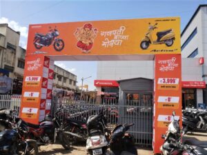 a huge printed arch gate for a ganpati mandal showing advertisements for Hero Honda motorcycles