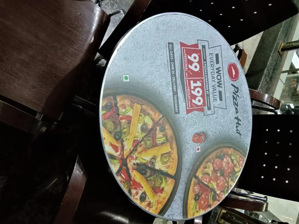 advertising pizzas in a restaurant via furniture printing on top of a table