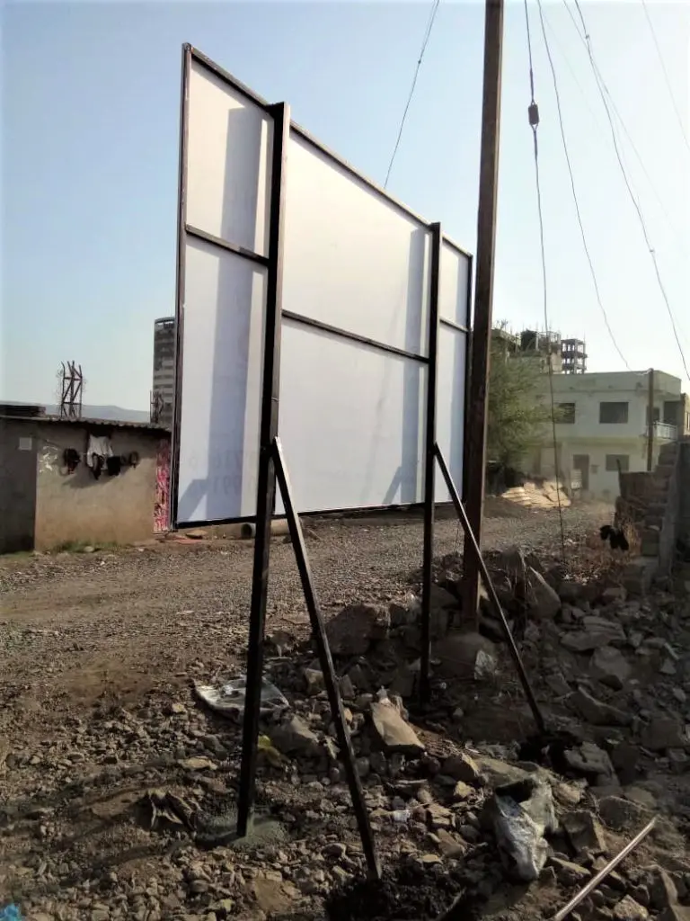 back view of a flex printed board stretched tightly on a metal frame with stand dug into the earth