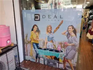 branding on the glass door of a Deal Jeans store using one way vinyl