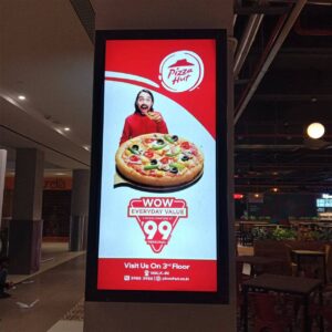 night view of a glowing backlit board fixed on a pillar showing advertisement for pizza hut