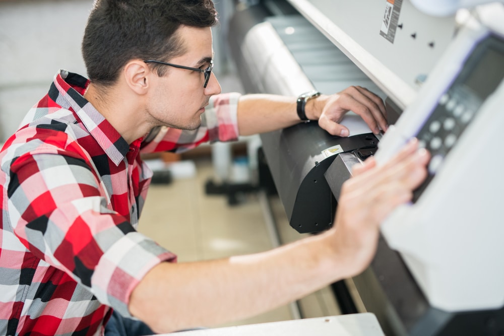 printer technician repairing a wide fomat printer