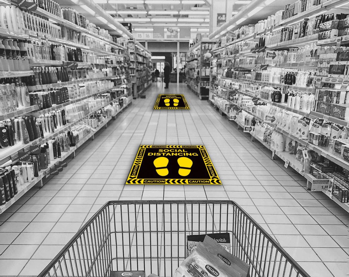 social distancing floor stickers pasted on the ground in a supermarket aisle