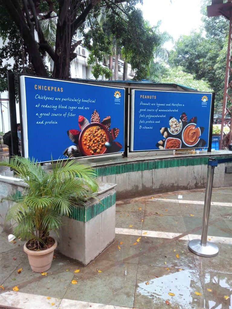 two backlit boards printed on flex mounted on the parapet wall of an outdoor cafe
