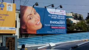 flex printing of a huge hoarding for the Jehangir hospital mounted on the side of a road advertising their dental services