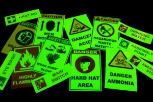 glow in the dark safety signs emitting a greenish light in full darkness