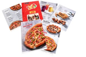 Restaurant menu cards printed on stiff and thick cardboard. All of them spread out to show pizza images.