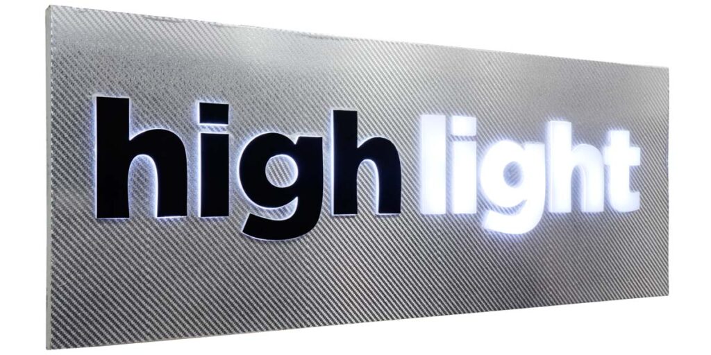 Laser cut acrylic letters fixed on a silver ACP box to create glow sign board of the 'High Light' logo. LEDs making the acrylic letters glow from the front and side edges. Black vinyl pasted on the word High to give an edge glow. The word Light glows from the front as well as the sides