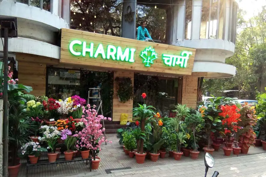 3D acrylic glow sign board for the Charmi store with letters mounted on a wooden panel