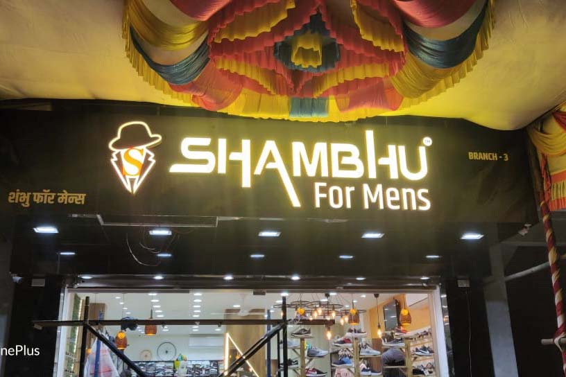 Brightly glowing open dot LED sign board for the Shambhu Saloon with the letters made of gold metallic letters