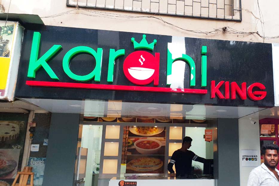 Thick letters made from green and red acrylic cut in the shape of the Karhai King logo mounted on a black ACP frame