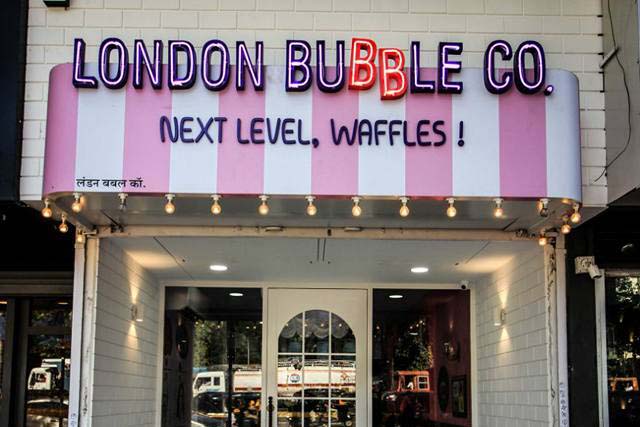 Colorful neon sign board created for the storefront of a waffles shop named the London Bubble Company