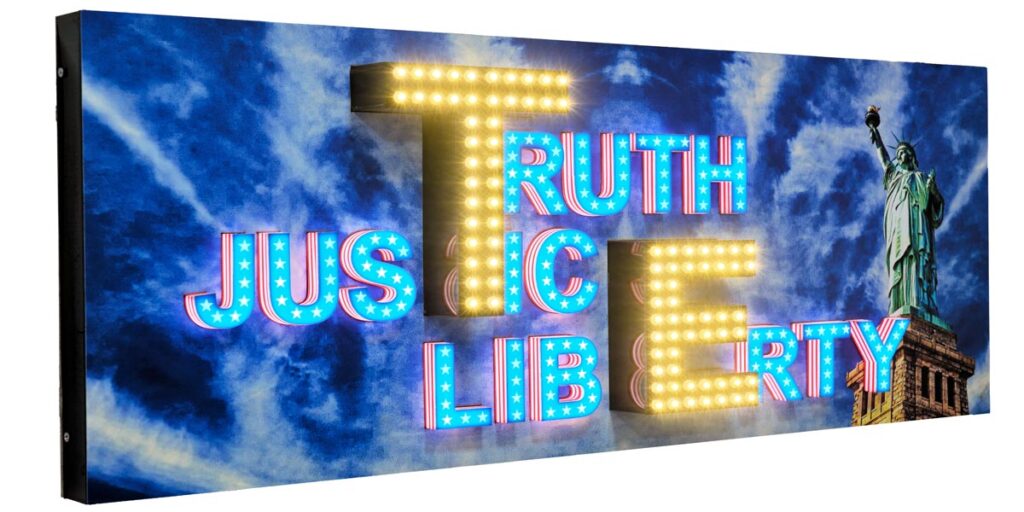 3D acrylic letters on a sign board with open, dot LEDs fixed on top to make the board shine very brightly. In-cut acrylic letters on the side spelling out the word ‘Truth, Justice, Liberty’. Statue of Liberty image in the background on the ACP frame