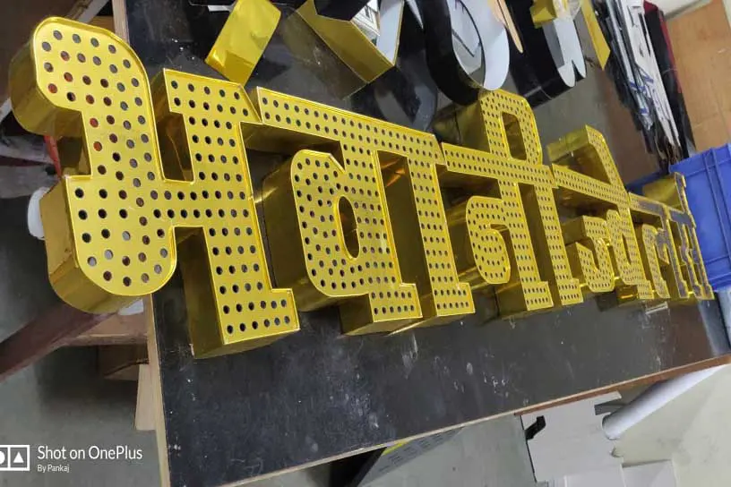 Sign letters being fabricated out of gold finish metal with holes drilled on the top surface to insert open dot LEDs