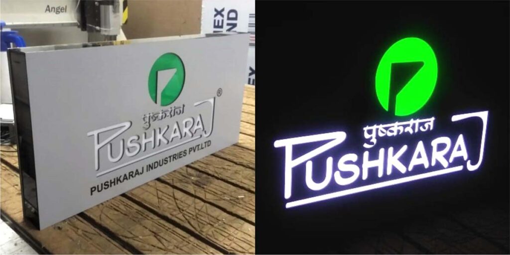 Day and night view of a glow sign board. White and green acrylic letters stencil cut in an ACP base frame make for a great looking shop board of the Pushkraj store