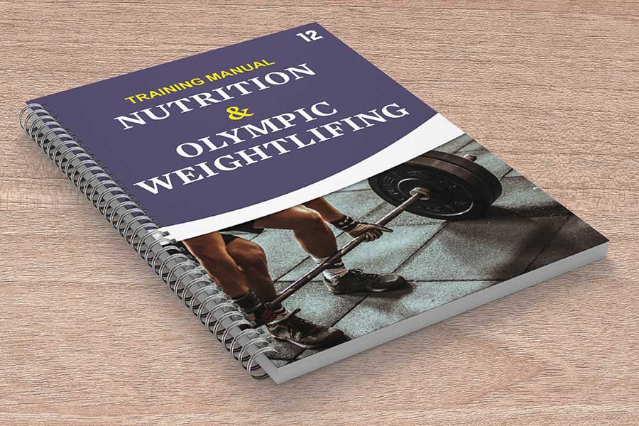 Printed training manual for a olympic weightlifter spiral bound and placed on a wooden surface