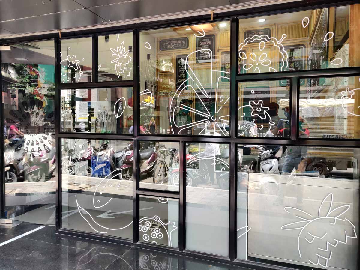 White ink printing of graphical designs and icons on the glass frontage of a restaurant