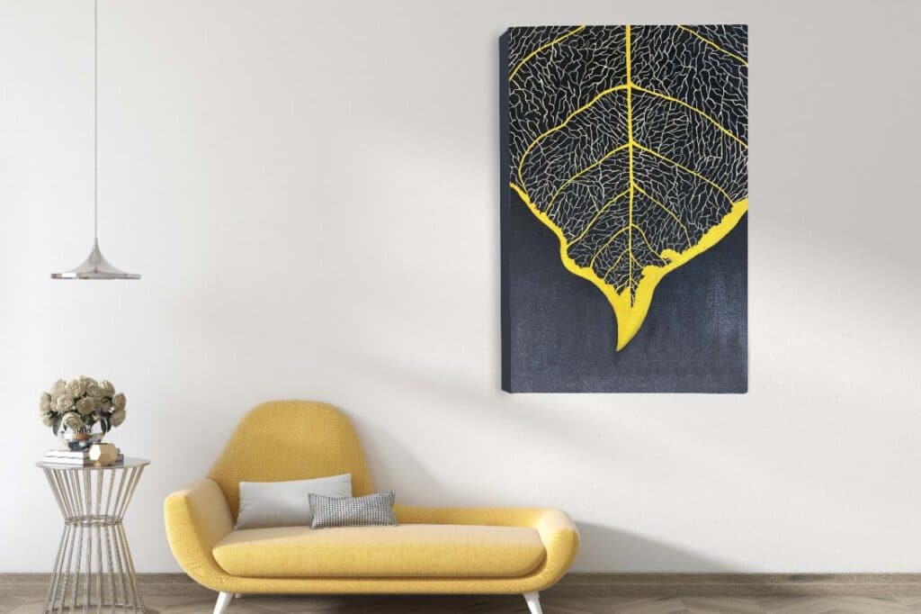 A large canvas painting showing the veins of a leaf chased in gold. This painting is placed on the wall in a living room next to a sofa.
