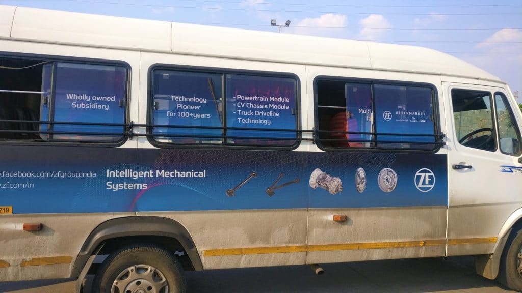 The windows of a Tempo Traveller mini van covered with custom-printed one-way vision films to show the company’s services, brand colours and tag lines.