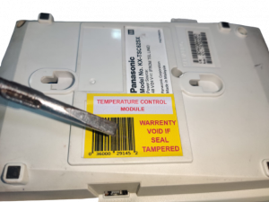 Warranty void sticker pasted on the screw casing of a machine to warn unauthorised people against opening sensitive equipment