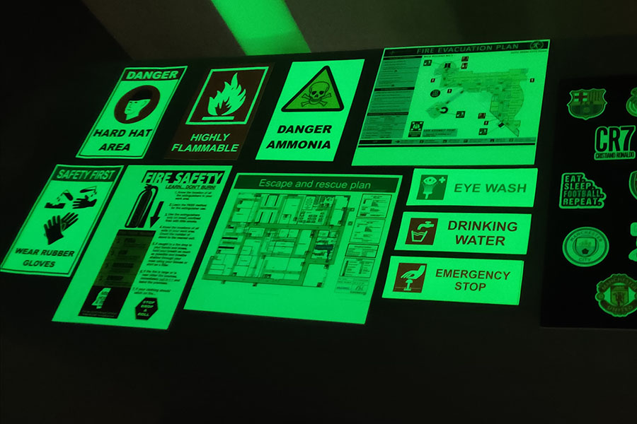 Auto glow safety signs emitting a bright green glow when seen in the dark