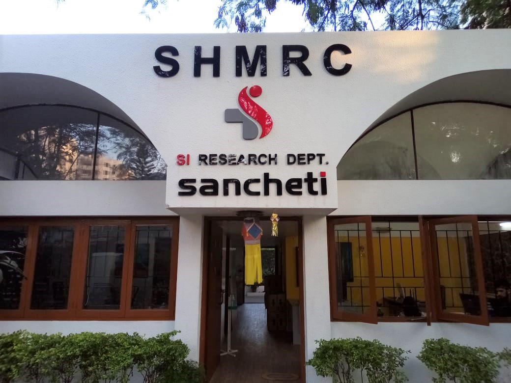 Black and red laser cut acrylic letters in the shape of the Sancheti Hospital mounted at the entrance of a building