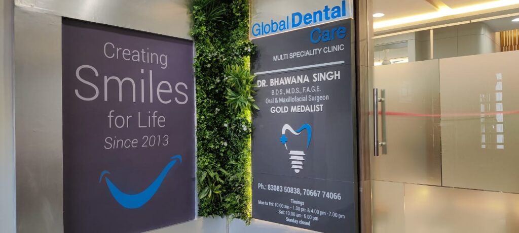 A dental clinic’s entry with the tag line as a wallpaper print the name of the clinic cut in 3D acrylic letters and the glass entry door having a frosted film for privacy 