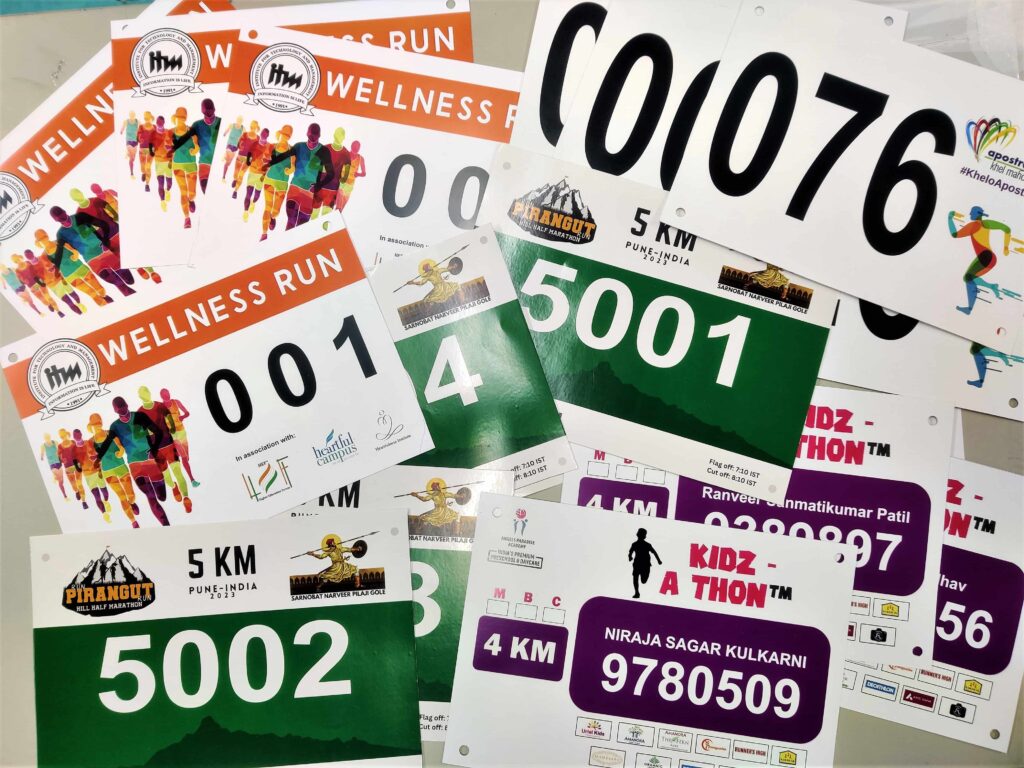 Different designs of colourful race bibs spread out on a table