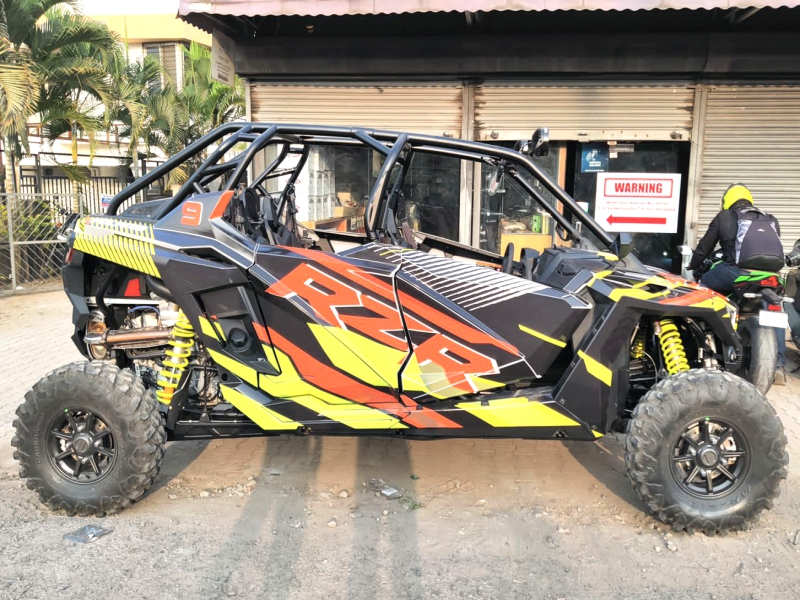 A vibrant orange and yellow pattern along with the letters ‘RZR’ emblazoned across an all-terrain vehicle using custom printed all weather stickers