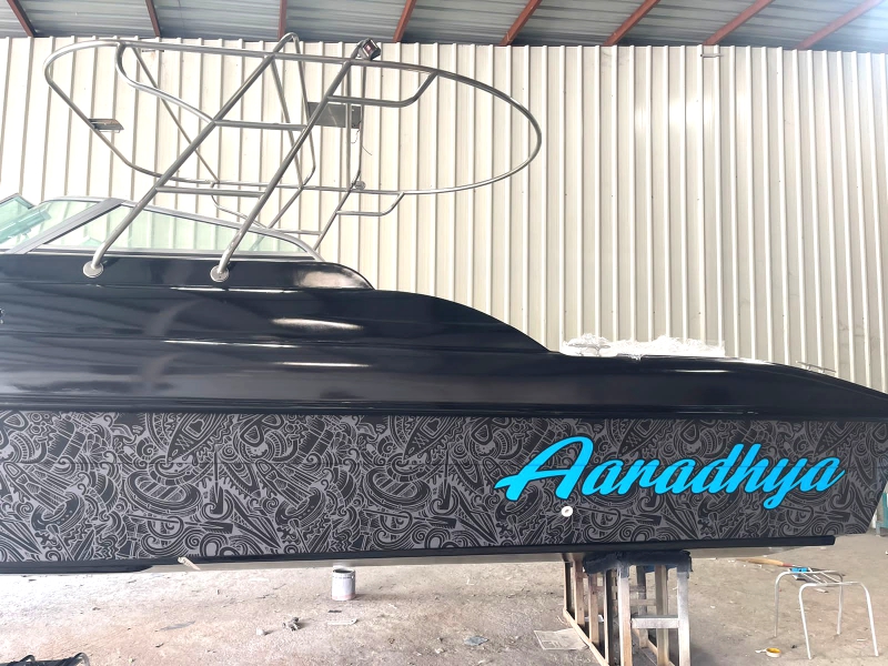 a black speedboat branded with a custom design and the name of the vessel “Aaradhdhya” using waterproof all weather vinyl print